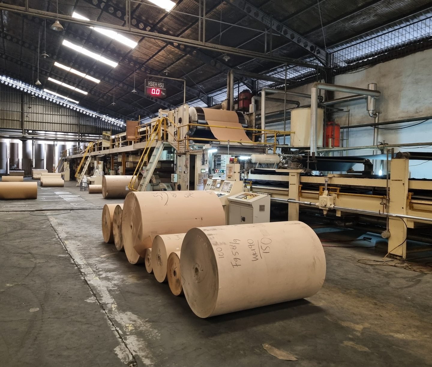 Mesin corrugator dan gulungan kertas di pabrik kardus PT Multi Artha Abadi, Tangerang